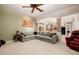 Spacious living room featuring neutral carpet, a comfortable gray couch, and access to the kitchen at 4662 W Fallen Leaf Ln, Glendale, AZ 85310