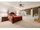 Spacious main bedroom with a four-poster bed, ceiling fan, and large windows at 4662 W Fallen Leaf Ln, Glendale, AZ 85310