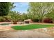 Backyard pool area featuring a rock waterfall and vibrant landscaping at 4662 W Fallen Leaf Ln, Glendale, AZ 85310