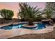 Resort-style pool boasts a center island with palm tree and a stone waterfall at 4662 W Fallen Leaf Ln, Glendale, AZ 85310