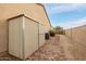 Functional side yard with storage shed, desert landscaping, and a gated entrance, offering practicality at 4662 W Fallen Leaf Ln, Glendale, AZ 85310