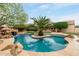 Beautiful backyard swimming pool with a waterfall feature, a central palm tree island, and a lush lawn at 4662 W Fallen Leaf Ln, Glendale, AZ 85310