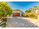 Charming single-story home featuring a brown garage door, well-manicured landscaping, and palm trees at 4747 W Sunnyside Ave, Glendale, AZ 85304