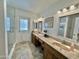 Bathroom featuring double sinks, wood vanities, and a glass-enclosed shower with a door to the outside at 5146 W Echo Ln, Glendale, AZ 85302