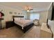 Cozy bedroom with a ceiling fan, a dark wood bed frame, and a bright window at 5146 W Echo Ln, Glendale, AZ 85302