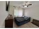 Simple bedroom with a bed, dresser, fan, neutral walls, plush carpet, and ample natural light at 5146 W Echo Ln, Glendale, AZ 85302