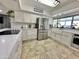 Modern kitchen with stainless steel appliances, white cabinets and countertops, and a farm sink beneath a large window at 5146 W Echo Ln, Glendale, AZ 85302