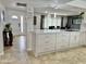 Spacious kitchen with white cabinetry, countertops, and a view into the dining area and front door at 5146 W Echo Ln, Glendale, AZ 85302