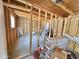 Unfinished outbuilding featuring exposed wood framing, a window, concrete flooring, and various construction materials at 5146 W Echo Ln, Glendale, AZ 85302