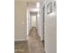 Long hallway with tile flooring and white doors leading to various rooms at 528 E Wolf Hollow Dr, Casa Grande, AZ 85122