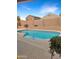 Beautiful backyard with a sparkling pool, brick wall and clear blue sky at 528 E Wolf Hollow Dr, Casa Grande, AZ 85122