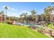 Landscaped water feature with fountains, lush grass, rocks, mature trees, and apartment buildings in the background at 5401 E Van Buren St # 1103, Phoenix, AZ 85008