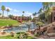 Well-kept landscaping of a water feature with fountains, palm trees and grass in front of apartment buildings at 5401 E Van Buren St # 1103, Phoenix, AZ 85008