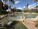 Relaxing pond featuring fountains surrounded by rocks, grass and mature trees under sunny skies at 5401 E Van Buren St # 2053, Phoenix, AZ 85008