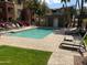 Clean community pool with nearby restroom facilities surrounded by lounge chairs and grass at 5401 E Van Buren St # 2053, Phoenix, AZ 85008