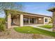 View of backyard with covered patio, outdoor kitchen, and manicured lawn at 5411 E Duane Ln, Cave Creek, AZ 85331