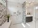 Sleek bathroom featuring a glass-enclosed shower, modern fixtures, and stylish herringbone tile accent wall at 5411 E Duane Ln, Cave Creek, AZ 85331