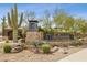 Elegant community entrance with stone accents, lush landscaping, and a welcoming sign at 5411 E Duane Ln, Cave Creek, AZ 85331