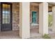 Inviting front porch with stone accents, columns, and a stylish dark front door at 5411 E Duane Ln, Cave Creek, AZ 85331