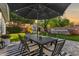 Outdoor dining area with a large patio table and umbrella, complemented by a lush, well-maintained lawn at 5529 N 19Th St, Phoenix, AZ 85016