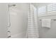 Bright bathroom with white subway tile, shower and tub combination, and shuttered window, creating a clean feel at 5529 N 19Th St, Phoenix, AZ 85016