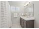 Bathroom with gray vanity, white countertop, framed mirror and shuttered window providing a clean and modern aesthetic at 5529 N 19Th St, Phoenix, AZ 85016