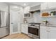 Well-equipped kitchen with stainless steel appliances, white cabinets, subway tile backsplash, and wood-look flooring at 5529 N 19Th St, Phoenix, AZ 85016