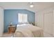 Primary bedroom features a large window and soft blue accent wall and soft lighting at 5735 E Mcdowell Rd # 197, Mesa, AZ 85215