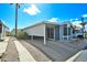 Street view of a charming blue home with a carport and lush landscaping at 5735 E Mcdowell Rd # 197, Mesa, AZ 85215