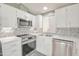 Bright kitchen with stainless appliances, white cabinets, and a decorative tile backsplash at 5735 E Mcdowell Rd # 197, Mesa, AZ 85215