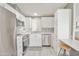 Well-lit kitchen featuring white cabinets, stainless steel appliances, and stylish backsplash at 5735 E Mcdowell Rd # 197, Mesa, AZ 85215