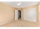 Carpeted bedroom with sliding closet doors and doorway to bathroom, ceiling fan at 5828 E Hoover Ave, Mesa, AZ 85206