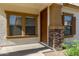 Inviting front porch with decorative stone columns, framed windows, and a solid front door at 5828 E Hoover Ave, Mesa, AZ 85206