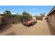 View of the expansive backyard featuring gravel, mature trees, and a utility trailer near the home at 6309 E Crocus Dr, Scottsdale, AZ 85254