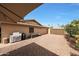 An exterior shot of the backyard showcasing a private outdoor space with gravel, a grill, and a partial shade covering at 6309 E Crocus Dr, Scottsdale, AZ 85254