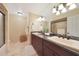 Bathroom featuring double sinks, dark wood cabinetry, and a large mirror at 6309 E Crocus Dr, Scottsdale, AZ 85254