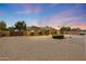 Inviting single-story home with manicured landscaping and a wide driveway set against a colorful evening sky at 6309 E Crocus Dr, Scottsdale, AZ 85254