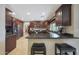 Modern kitchen featuring a breakfast bar with dark wood cabinets and granite countertops at 6309 E Crocus Dr, Scottsdale, AZ 85254