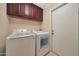 Convenient laundry room featuring a washer, dryer, and overhead storage at 6309 E Crocus Dr, Scottsdale, AZ 85254