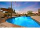 Serene pool area with brick trim, mature landscaping, and an umbrella for shade at 6309 E Crocus Dr, Scottsdale, AZ 85254