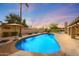 Beautiful backyard pool with mature landscaping, an umbrella table, and a brick paver surround at 6309 E Crocus Dr, Scottsdale, AZ 85254