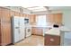 Spacious kitchen with natural wood cabinets, white appliances, and a tile backsplash at 8020 E Keats Ave # 271, Mesa, AZ 85209