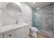 Bright bathroom featuring a marble walk-in shower and a modern vanity with a round mirror at 8442 E Chaparral Rd, Scottsdale, AZ 85250