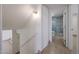 Hallway featuring a staircase and an open doorway that leads to a bathroom with a glass shower at 8442 E Chaparral Rd, Scottsdale, AZ 85250