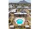 Aerial view of a community pool with lounge chairs, lush landscaping, and Mountain Park in the background at 8442 E Chaparral Rd, Scottsdale, AZ 85250