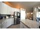 Well-lit kitchen with a large island, stainless steel refrigerator and white cabinets at 888 E Sheffield Ave, Chandler, AZ 85225