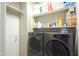 Functional laundry room with modern washer and dryer set and storage shelving at 888 E Sheffield Ave, Chandler, AZ 85225