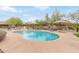 Beautiful community pool with lounge chairs, umbrellas, and clear blue water at 900 W Broadway Ave # 66, Apache Junction, AZ 85120