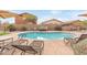 Inviting community pool with lounge chairs and umbrella for relaxing on a sunny day at 900 W Broadway Ave # 66, Apache Junction, AZ 85120