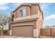 Exterior view of a two-story home, featuring neutral stucco and a brown garage door with adjacent trees at 900 W Broadway Ave # 66, Apache Junction, AZ 85120